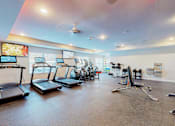Thumbnail 36 of 102 - A gym with treadmills, exercise bikes, and other equipment.