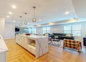 Thumbnail 53 of 102 - A modern kitchen with a white countertop and wooden flooring.