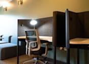 Thumbnail 56 of 102 - A room with a desk, chairs, and a couch.