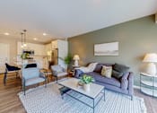 Thumbnail 66 of 102 - A modern living room with a grey couch and a coffee table.