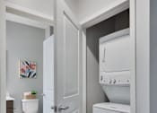 Thumbnail 6 of 98 - A white door opens to a bathroom with a toilet and a washing machine.