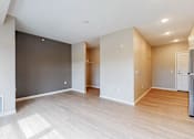 Thumbnail 101 of 102 - A spacious room with wooden flooring and white walls.