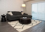 Thumbnail 19 of 98 - A grey couch with a white pillow is in front of a wallpapered wall.