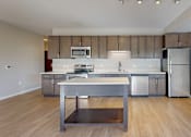 Thumbnail 35 of 98 - A kitchen with a stainless steel refrigerator and a wooden island.