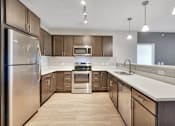 Thumbnail 46 of 98 - A modern kitchen with wooden cabinets and stainless steel appliances.