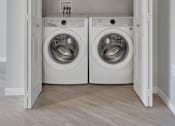 Thumbnail 50 of 98 - A laundry room with two washing machines and a white door.