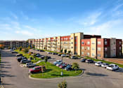 Thumbnail 55 of 98 - A parking lot in front of a row of apartment buildings.