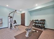 Thumbnail 68 of 98 - A gym room with a variety of equipment including a treadmill, weights, and a bench press.