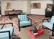 Thumbnail 75 of 98 - A room with a foosball table and two chairs.