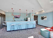 Thumbnail 76 of 98 - A bar area with white stools and a counter.