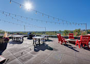 Thumbnail 85 of 98 - A sunny day at an outdoor seating area with tables and chairs.