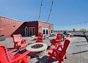 Thumbnail 87 of 98 - A patio with red chairs and a fire pit.