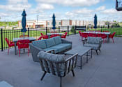 Thumbnail 89 of 98 - A patio with red chairs and blue umbrellas.