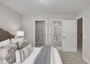 Thumbnail 8 of 16 - A bedroom with a bed, couch, and mirror.