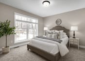 Thumbnail 11 of 16 - A bedroom with a large bed, a nightstand, and a potted plant.