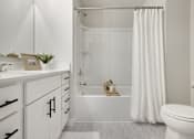 Thumbnail 14 of 16 - A white bathroom with a toilet, sink, and bathtub.
