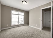 Thumbnail 15 of 16 - A room with a carpeted floor, a window, and a door.