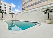 Thumbnail 3 of 18 - A pool with a white building in the background at The Palms on Main, Columbia