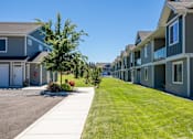 Thumbnail 52 of 53 - a row of houses with a lawn and a sidewalk at The Brix Apartments, Spokane Valley, WA, 99037