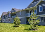 Thumbnail 49 of 53 - a blue house with a yard and trees in front of it at The Brix Apartments, Spokane Valley, WA, 99037