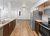 Thumbnail 1 of 53 - A kitchen with wooden cabinets and stainless steel appliances.at The Brix Apartments, Spokane Valley, Washington