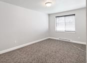 Thumbnail 26 of 53 - A room with a carpeted floor and a window with blinds.at The Brix Apartments, Spokane Valley, 99037