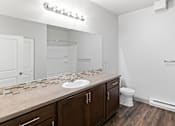 Thumbnail 30 of 53 - A bathroom with a white sink and brown cabinets.at The Brix Apartments, Washington