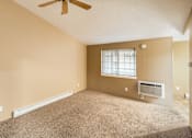 Thumbnail 37 of 73 - A room with a ceiling fan, window, and carpeted floor at Graymayre Crossing Apartments, Spokane, WA