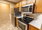 Thumbnail 45 of 73 - A kitchen with a stove, refrigerator, and microwave at Graymayre Crossing Apartments, Spokane, 99208