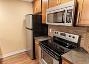 Thumbnail 58 of 73 - A black refrigerator and microwave in a kitchen with wooden cabinets at Graymayre Crossing Apartments, Spokane