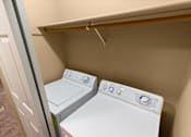 Thumbnail 65 of 73 - Two white washing machines in a small laundry room at Graymayre Crossing Apartments, Spokane, WA, 99208
