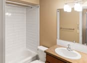 Thumbnail 66 of 73 - A white tiled bathroom with a white bathtub, toilet, and sink at Graymayre Crossing Apartments, Spokane, WA, 99208