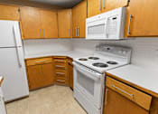 Thumbnail 17 of 73 - A kitchen with white appliances and wooden cabinets at Graymayre Crossing Apartments, Spokane, WA, 99208
