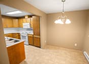 Thumbnail 19 of 73 - A kitchen with wooden cabinets and a tiled floor at Graymayre Crossing Apartments, Spokane, WA