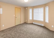 Thumbnail 27 of 73 - A room with a carpeted floor, two doors, and a window with blinds at Graymayre Crossing Apartments, Spokane, WA, 99208