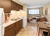 Thumbnail 5 of 12 - A kitchen with brown cabinets and a white refrigerator.