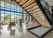 Thumbnail 16 of 63 - the lobby of a building with a staircase and tables and chairs
