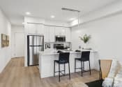 Thumbnail 2 of 63 - an open kitchen with a large island with two bar stools
