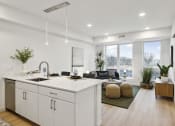 Thumbnail 4 of 63 - an open kitchen and living room with white cabinets and a large window