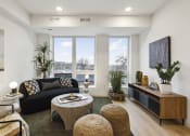 Thumbnail 8 of 63 - a living room with a couch and a coffee table and large windows
