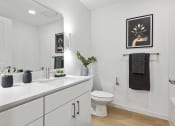 Thumbnail 9 of 63 - a bathroom with a sink and a toilet and a mirror
