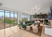 Thumbnail 20 of 63 - a community space with a green couch and a view of the city