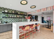 Thumbnail 24 of 63 - Community room kitchen with a long white counter and a bar with chairs