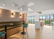 Thumbnail 27 of 63 - a seating area with tables and chairs and a counter in a room with windows