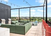 Thumbnail 30 of 63 - a rooftop patio with green couches and chairs and a bar
