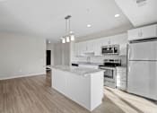 Thumbnail 37 of 39 - A modern kitchen with stainless steel appliances and a marble island.