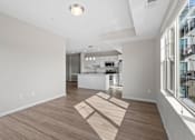 Thumbnail 32 of 39 - A spacious kitchen and living room with wooden flooring and white walls.
