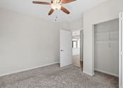 Thumbnail 30 of 39 - A room with a ceiling fan and carpeted floor.