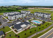 Thumbnail 3 of 6 - A large apartment complex with a swimming pool and a playground.
