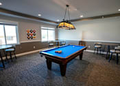 Thumbnail 7 of 13 - A pool table in a room with a hanging light fixture.